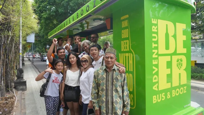 Guests and local Balinese crew posing together beside the bus