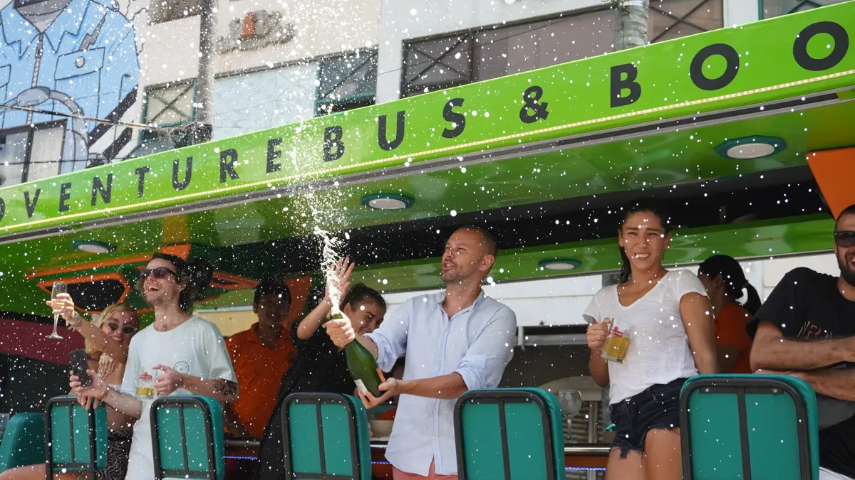 Champagne spray celebration under the Bus and Booz sign