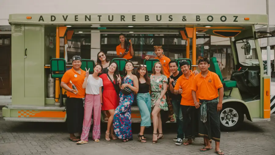 The full crew — guests and Balinese hosts — posing in front of the party bus