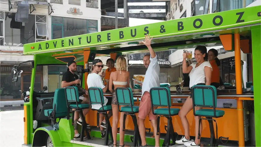 Guests cheering with drinks at the bar of the party bus