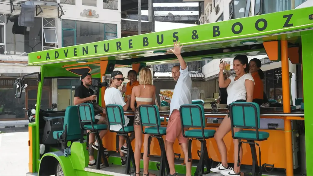 Guests seated at the bar counter on the bus, one standing with arm raised
